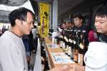 振る舞い焼酎を楽しむ来場者＝伊佐市菱刈田中