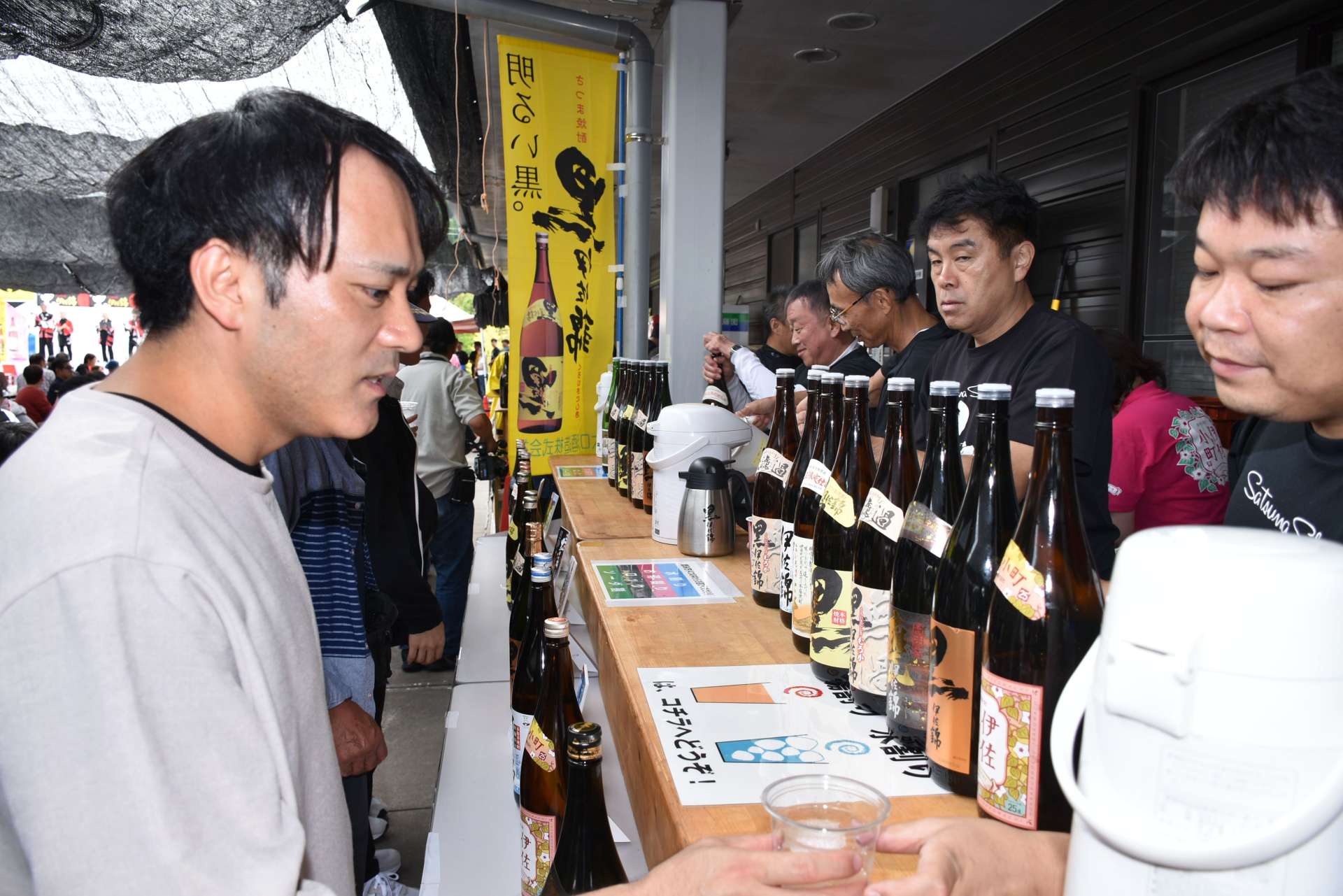 振る舞い焼酎を楽しむ来場者＝伊佐市菱刈田中