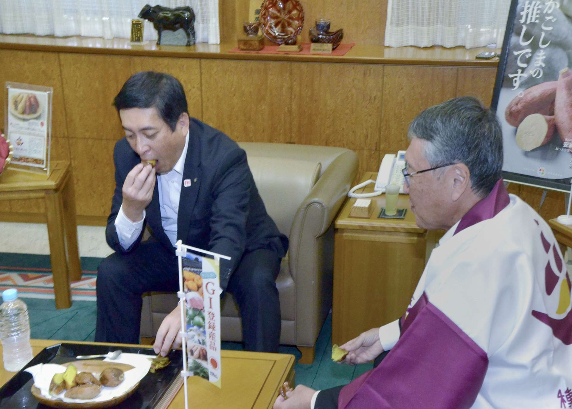「種子島安納いも」の焼き芋を味わう塩田康一知事（左）＝２９日、県庁