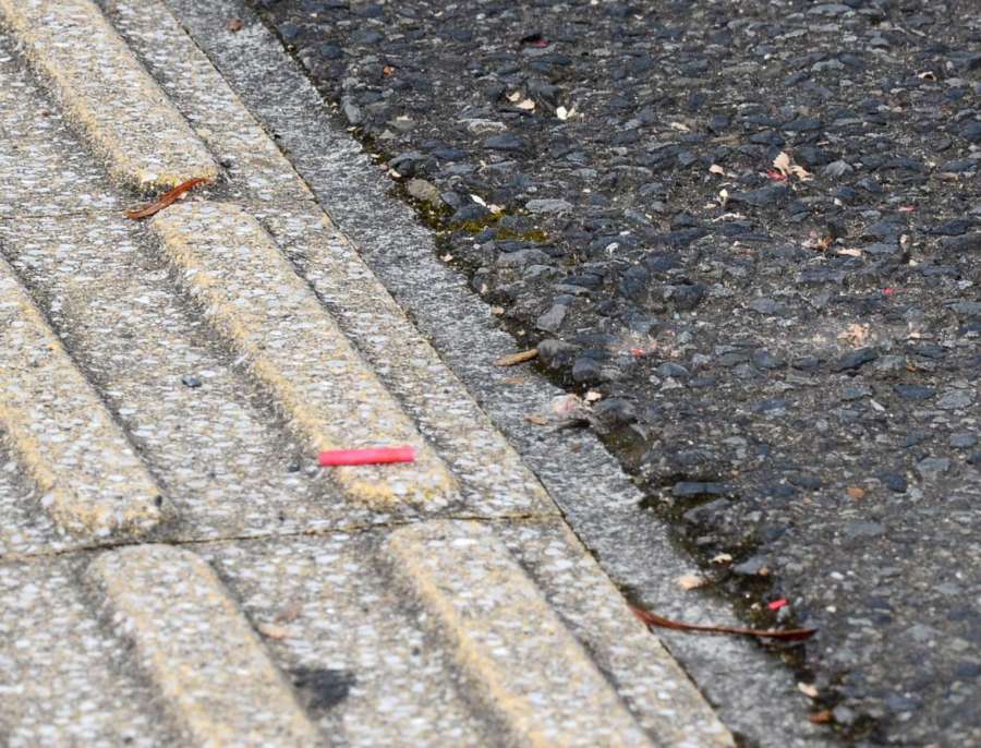 〈関連〉事務所に面した歩道に散乱した爆竹のかけらのようなもの＝２８日午前９時５９分、鹿児島市谷山中央３丁目