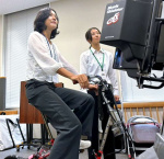 自転車シミュレーターで安全な運転方法を学ぶ外国人技能実習生＝２６日、鹿児島市のカクイックス交流センター