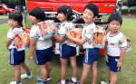 お菓子の防災リュックサックを背負い、笑顔を見せる園児たち＝指宿市の開聞保育園
