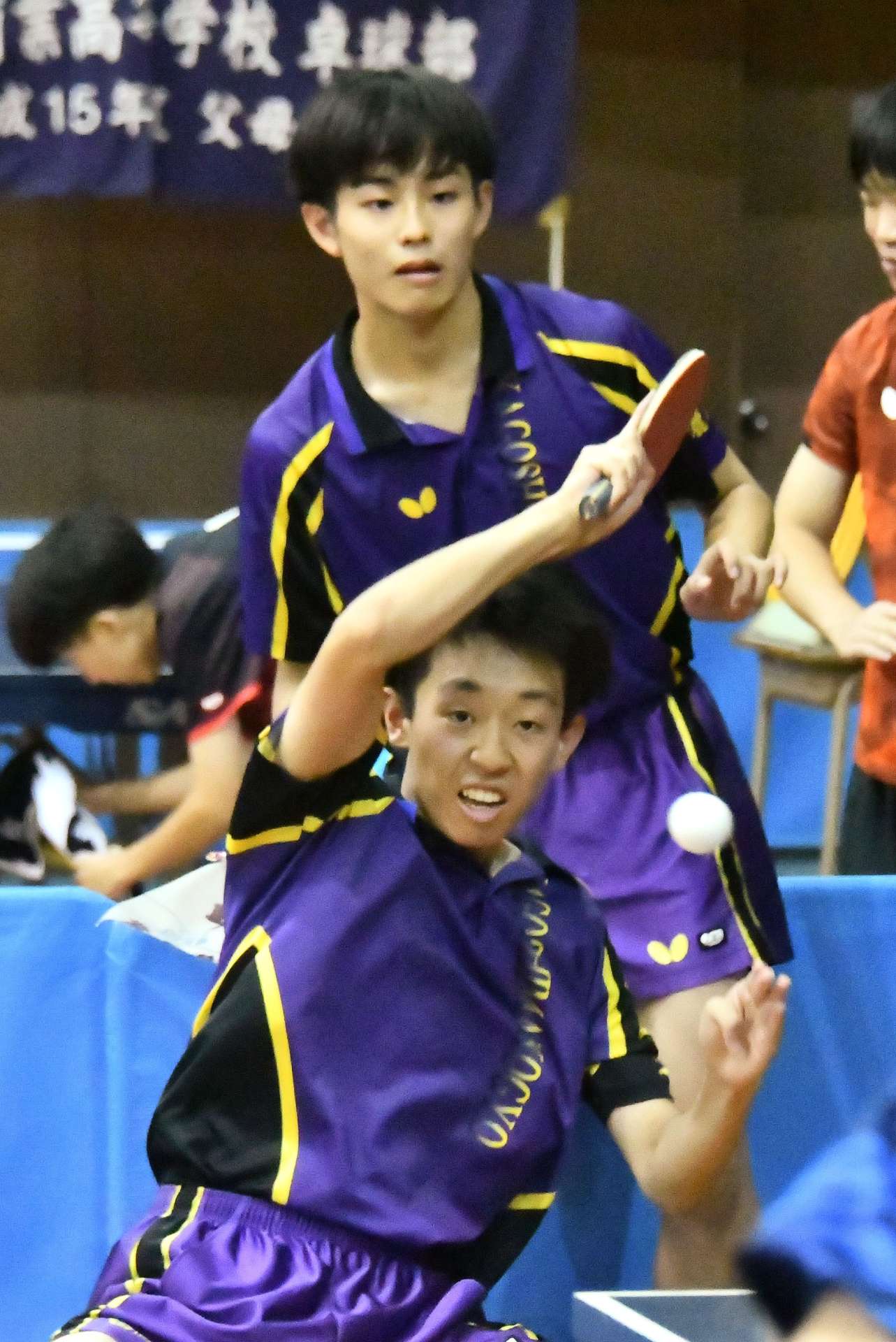 男子決勝リーグのれいめい戦、ダブルスで好連係を見せる鹿工の田中（手前）・八ケ代組＝県体育館