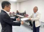 県職員に要請書を手渡す堀浩一郎代表世話人（右）＝１日、県庁