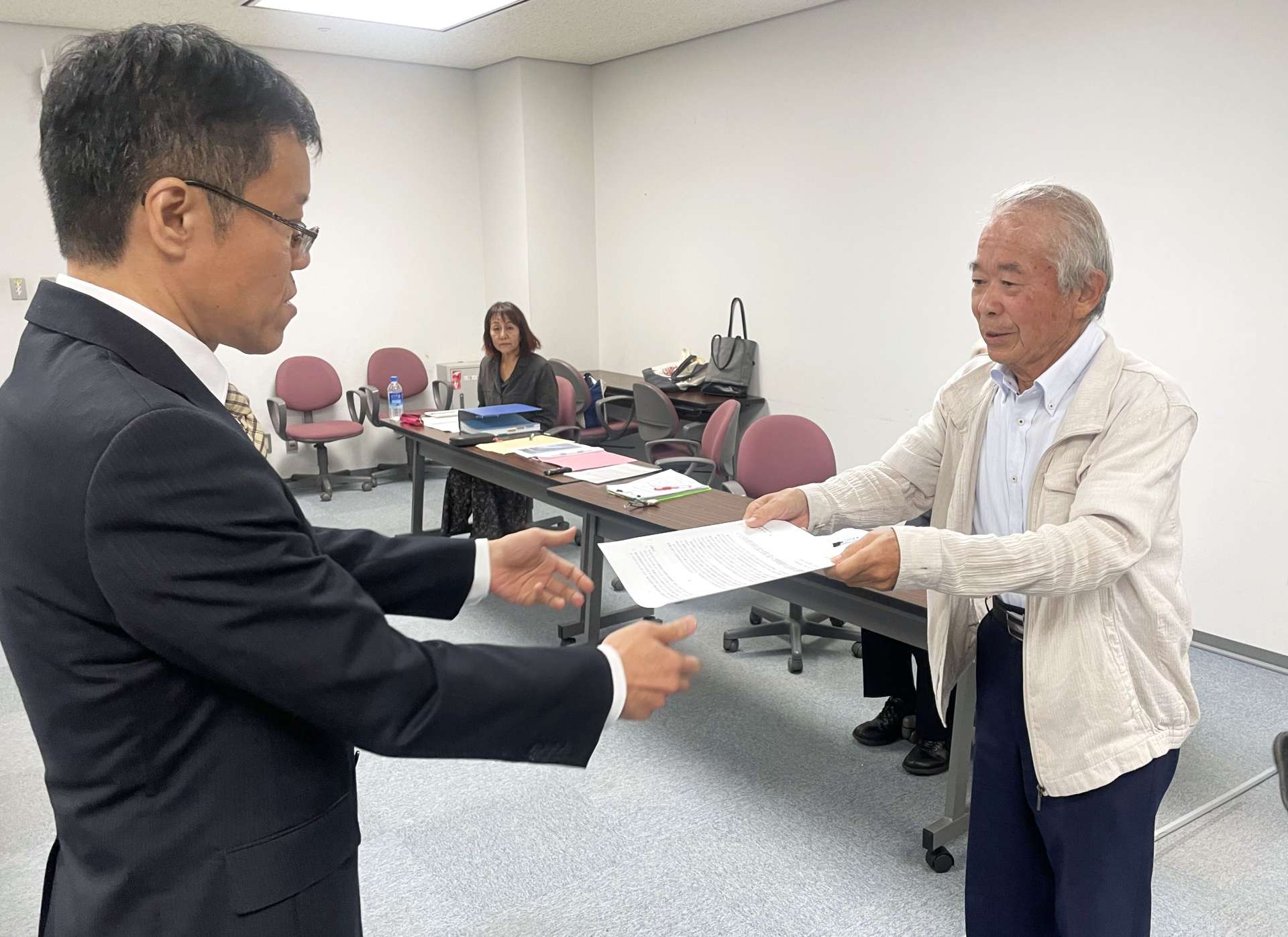 県職員に要請書を手渡す堀浩一郎代表世話人（右）＝１日、県庁
