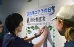 野生のコアラを守るための行動を書いたユーカリの葉を貼りつける参加者＝鹿児島市の平川動物公園