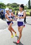 鹿工の６区・橋口（右）がアンカー桑野にたすきをつなぐ＝指宿市