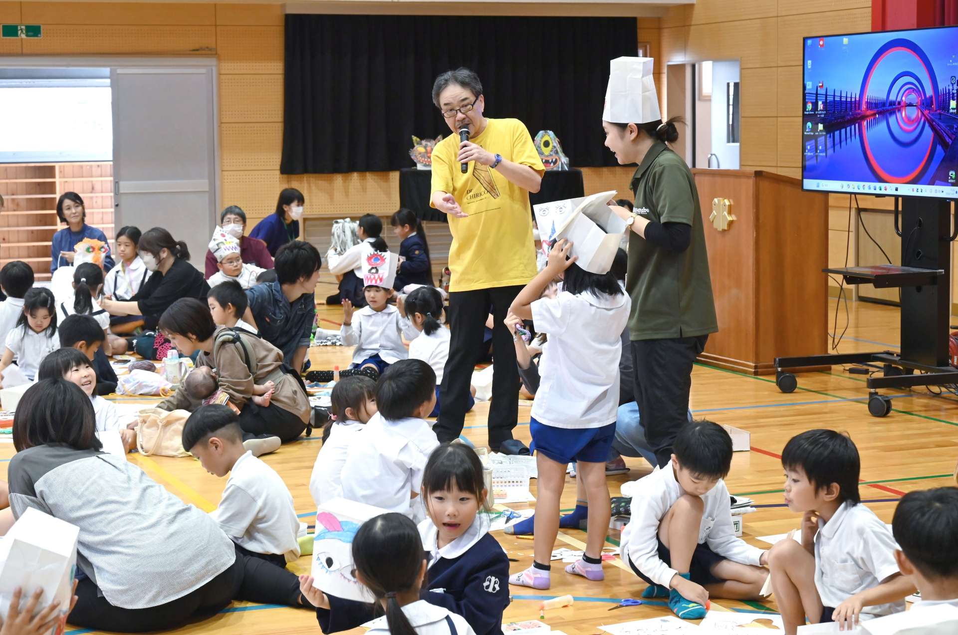 子どもたちが作った妖怪帽子を褒める広瀬克也さん＝南九州市の川辺小学校