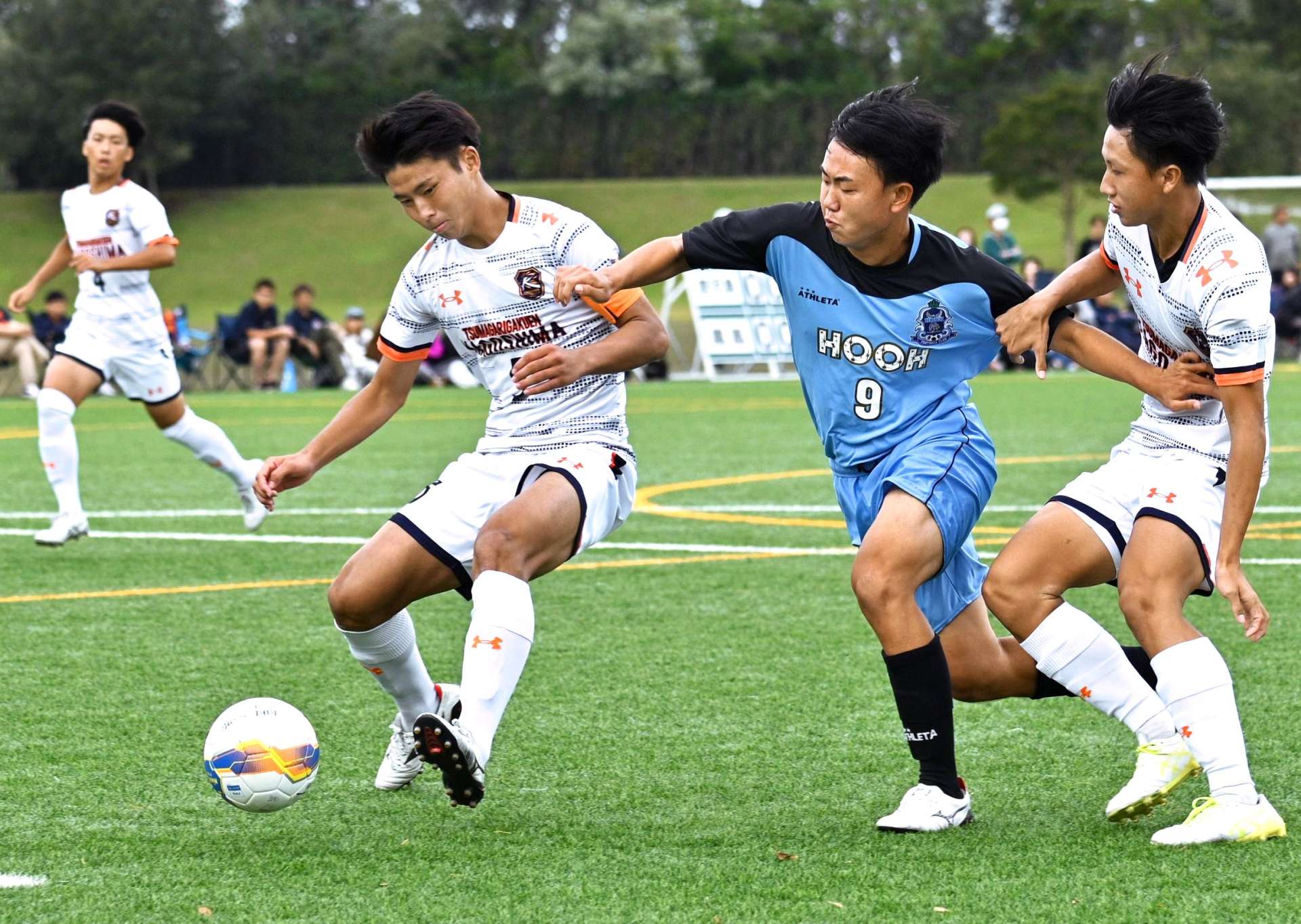 鳳凰ＦＷの突破を体を寄せて防ぐ鹿児島のＤＦ大窪（左）と和田（右）＝桷志田サッカー場