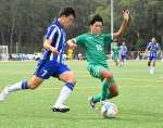 前半、ゴール前で競り合う鹿城西の福留（左）と指宿商の今栁田＝コトブキサッカーフィールド吹上