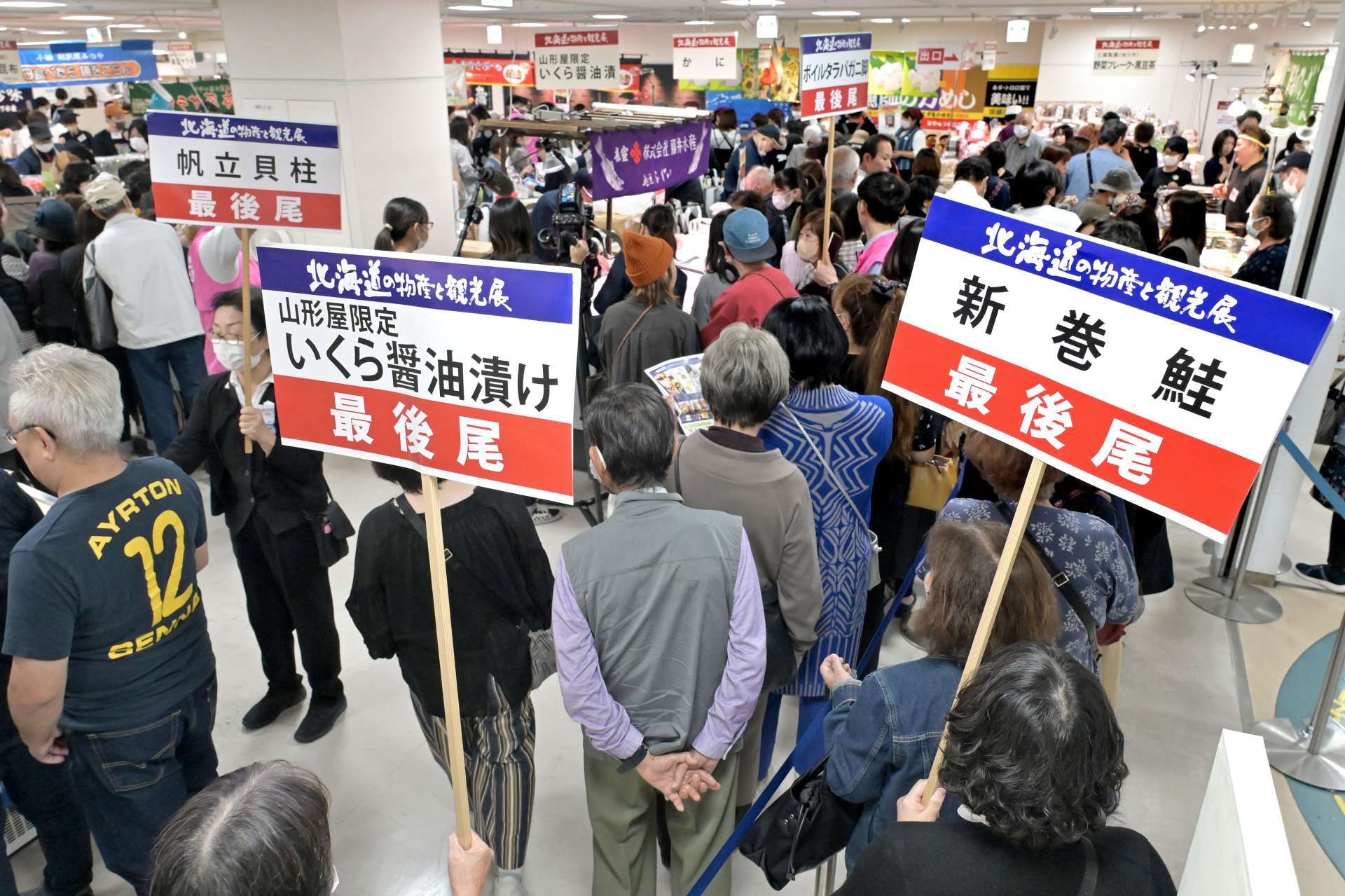 人気商品売り場の周囲にできる買い物客の長い列＝６日午前、鹿児島市の山形屋