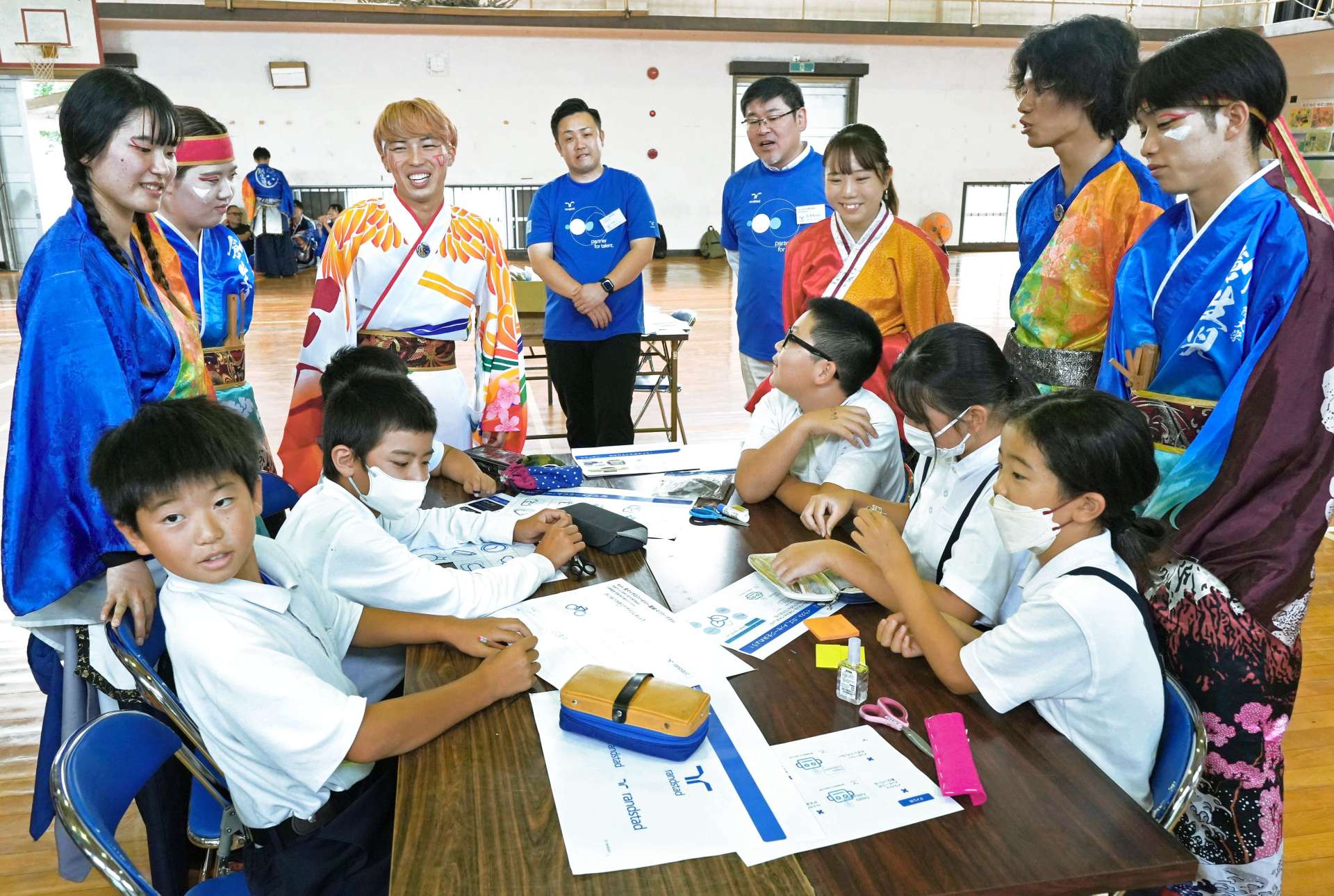 踊り手の意見を聞きながらノベルティーグッズのデザインを考える児童＝垂水市の協和小学校