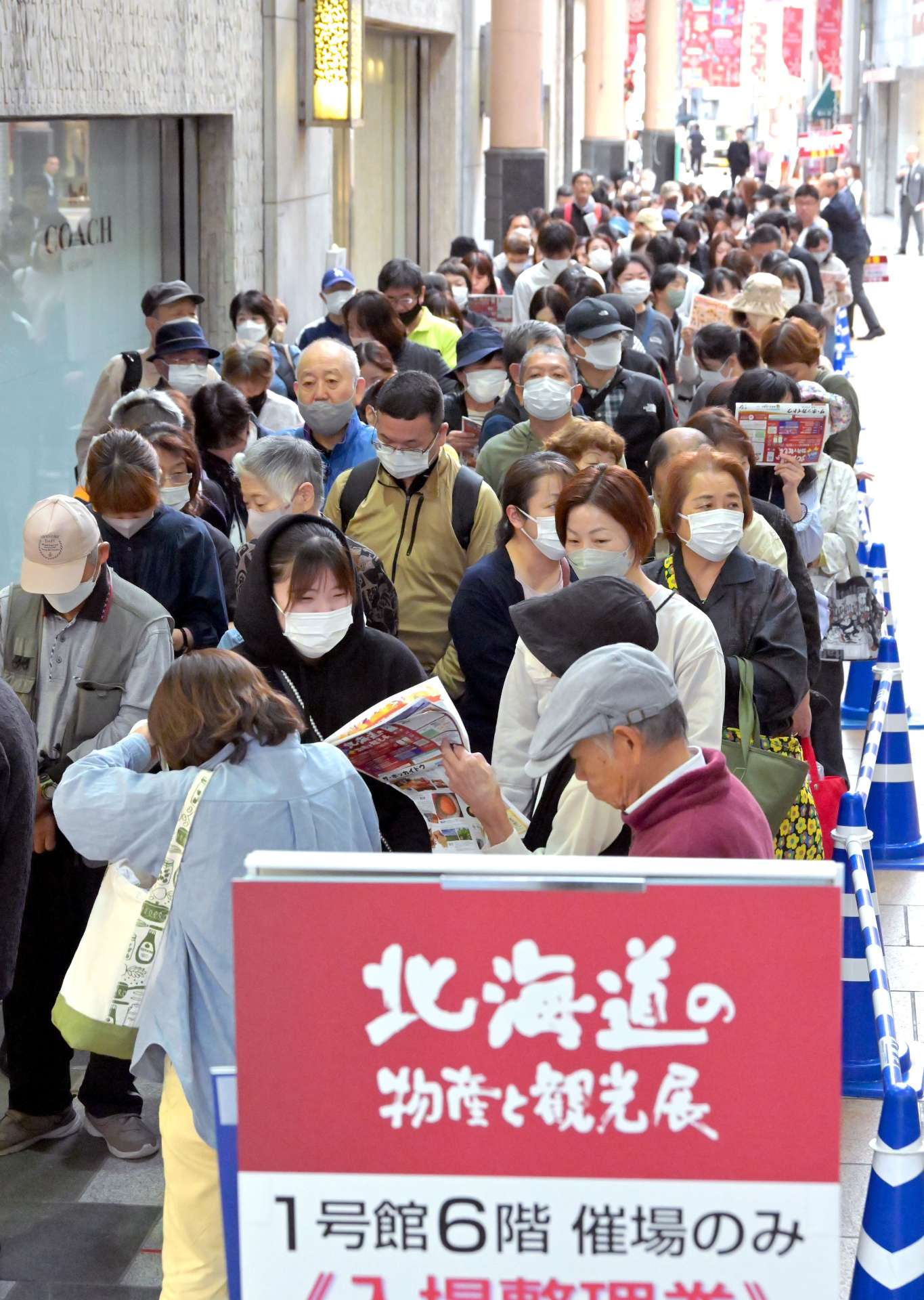 長蛇の行列をつくり開店を待つ買い物客ら＝６日午前９時４０分、鹿児島市の山形屋