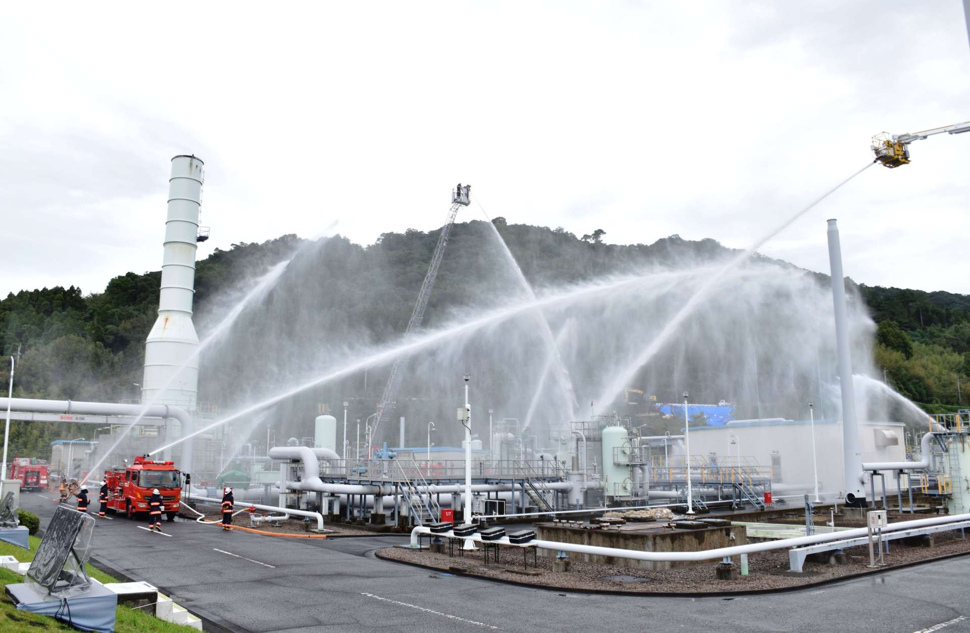 火災を想定し、一斉放水する消防車両＝いちき串木野市の串木野国家石油備蓄基地