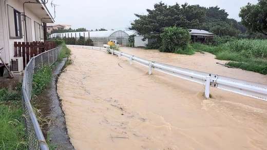 排水路（ガードレールから左）があふれ、冠水した町道。車が一時立ち往生した＝与論町茶花（同町提供）