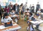 最後の同窓会で母校を訪れ、タブレット端末を使った授業を見学する卒業生＝７日、南九州市頴娃の粟ケ窪小学校