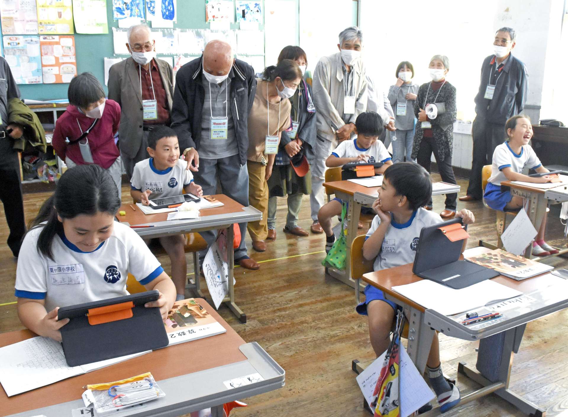 最後の同窓会で母校を訪れ、タブレット端末を使った授業を見学する卒業生＝７日、南九州市頴娃の粟ケ窪小学校