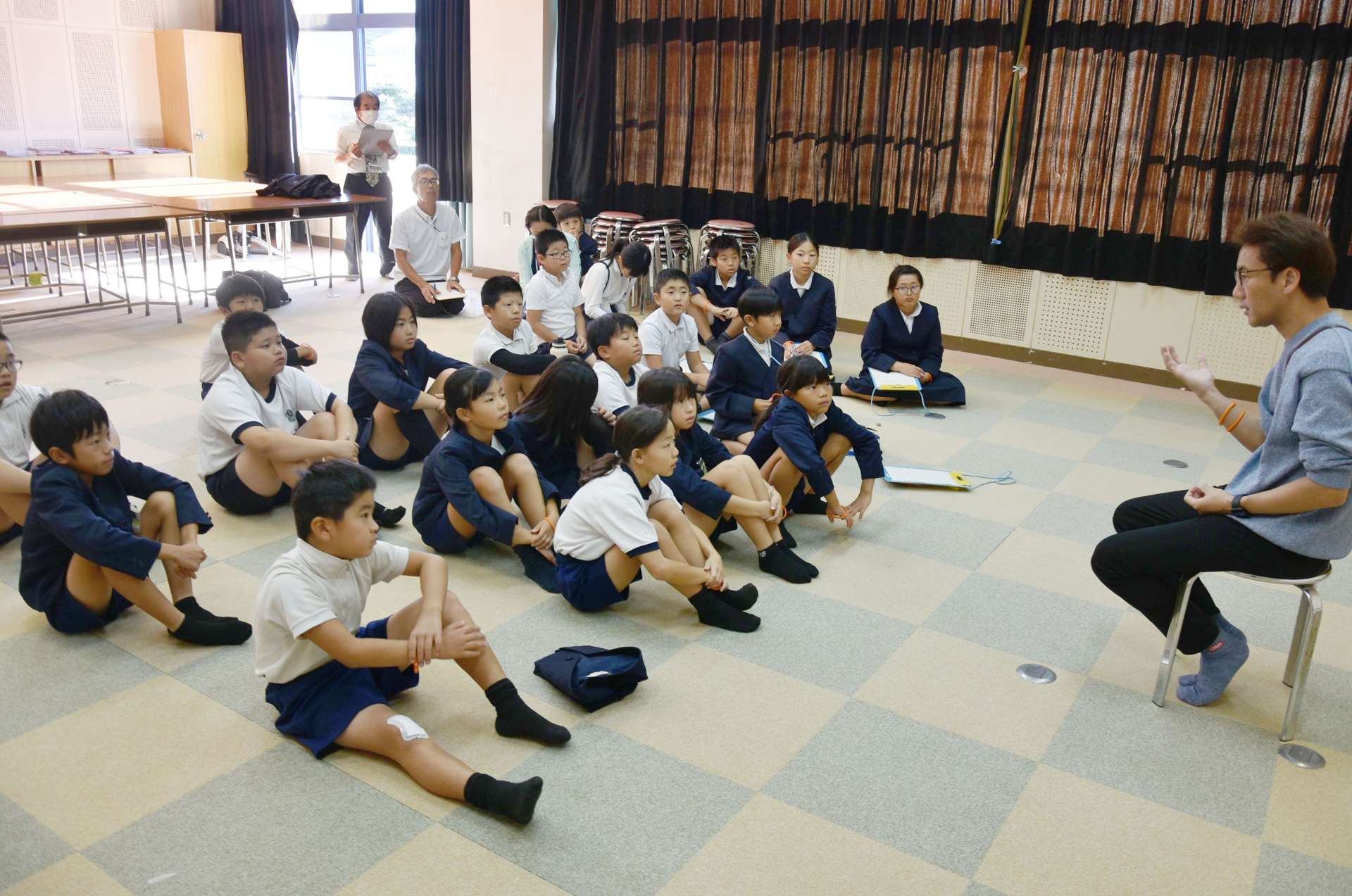 認知症当事者の体験を話す丹野智文さん（右）＝７日、錦江町の大根占小学校