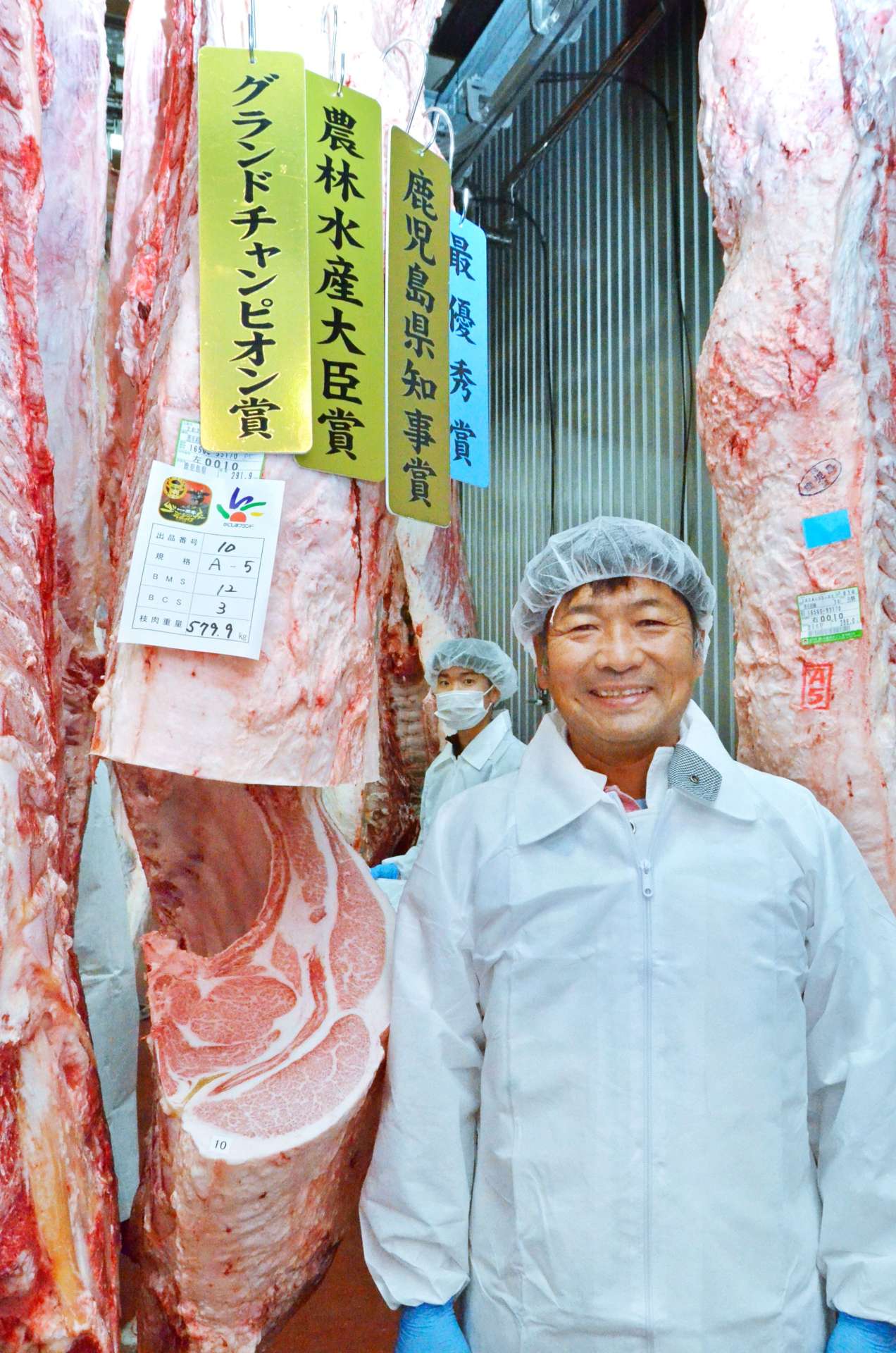 グランドチャンピオンに輝いた鶴喰康行さんと出品した枝肉＝１１日、南九州市のＪＡ食肉かごしま南薩工場