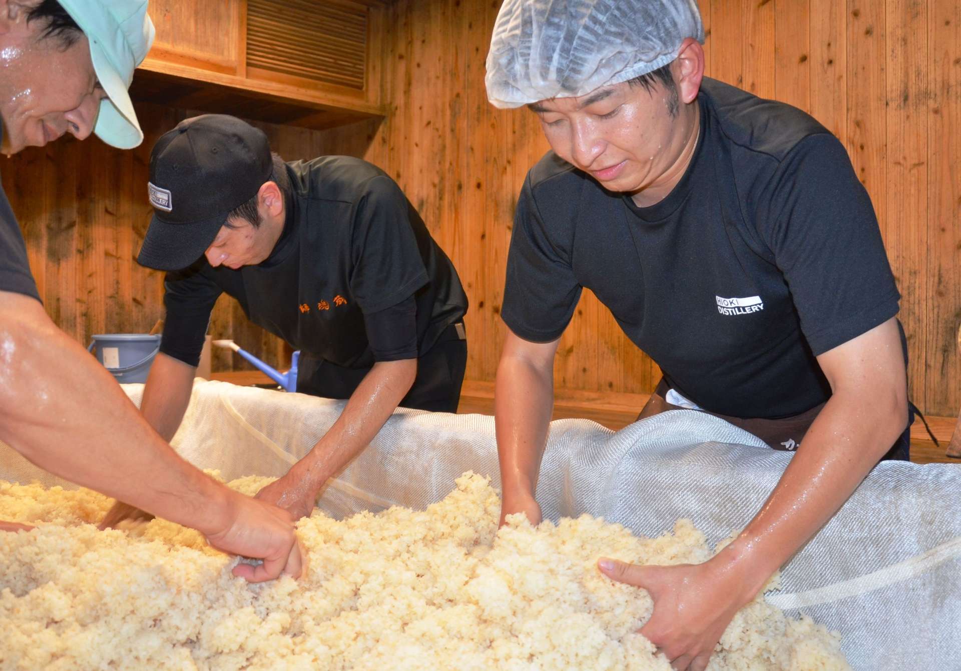 種こうじの植え付けを体験する近藤雄介さん（右）＝日置市日吉の小正醸造日置蒸溜蔵師魂蔵