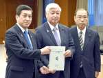 中谷元防衛相（中央）に要請書を手渡す塩田康一知事（左）＝１２日、防衛省