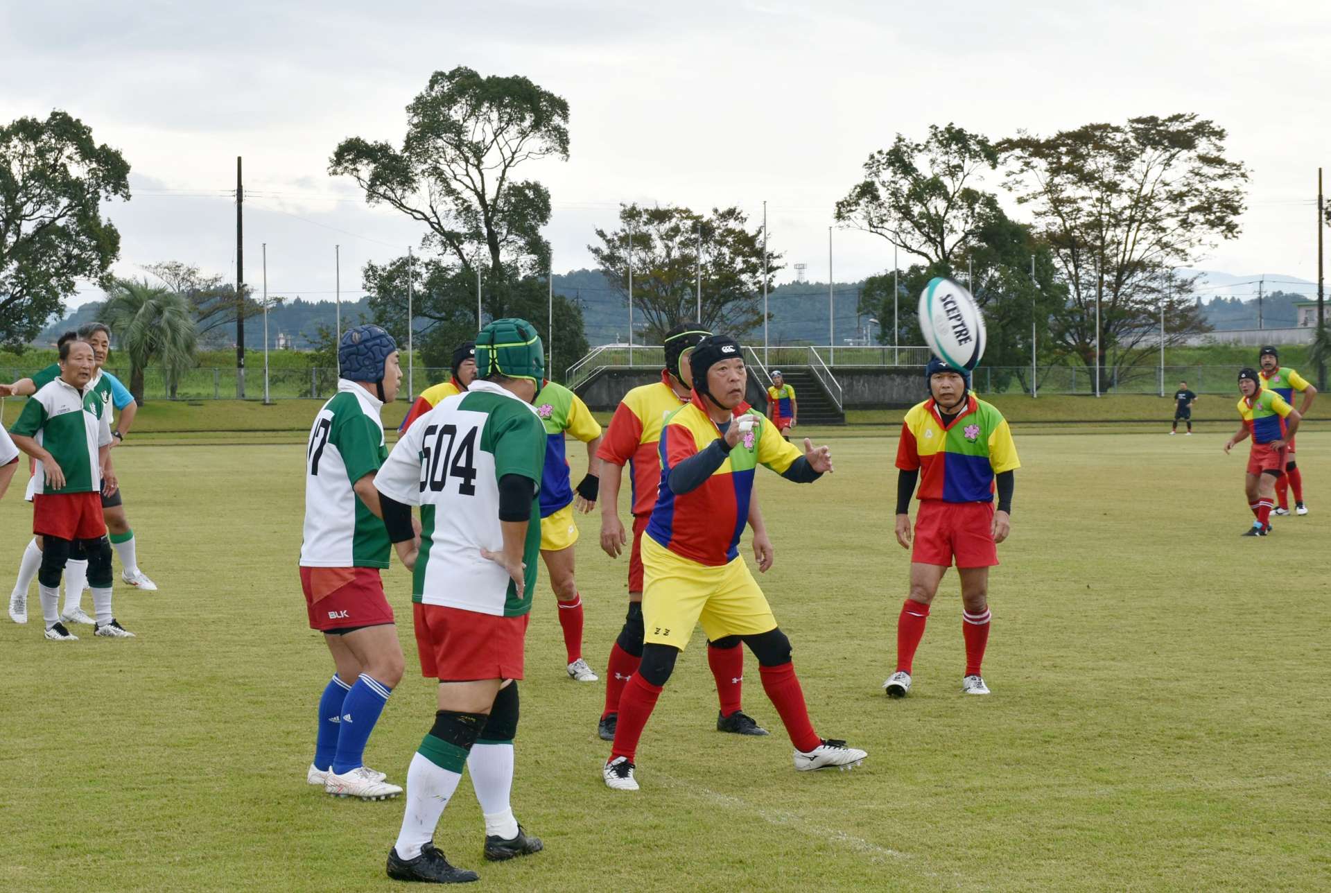 はつらつとしたプレーを見せるシニアラグビーの選手たち＝伊佐市陸上競技場