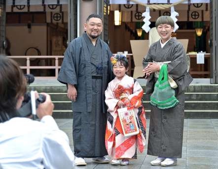 晴れ着姿で記念撮影に臨む家族連れ＝１５日午前、鹿児島市の照国神社