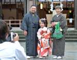 晴れ着姿で記念撮影に臨む家族連れ＝１５日午前、鹿児島市の照国神社