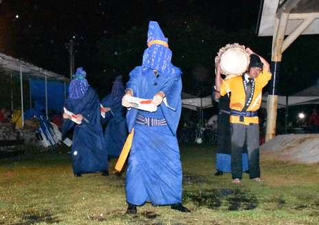 頭巾を巻いて顔を覆い、扇を持って踊る二番組＝１５日、与論町立長の地主神社