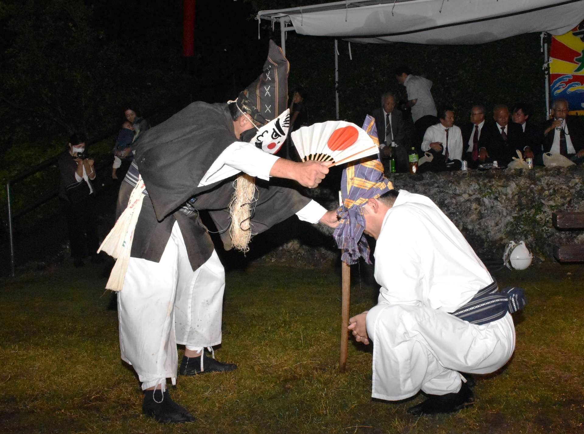 独特の面を付けて親子の掛け合いを演じる一番組＝１５日、与論町立長の地主神社