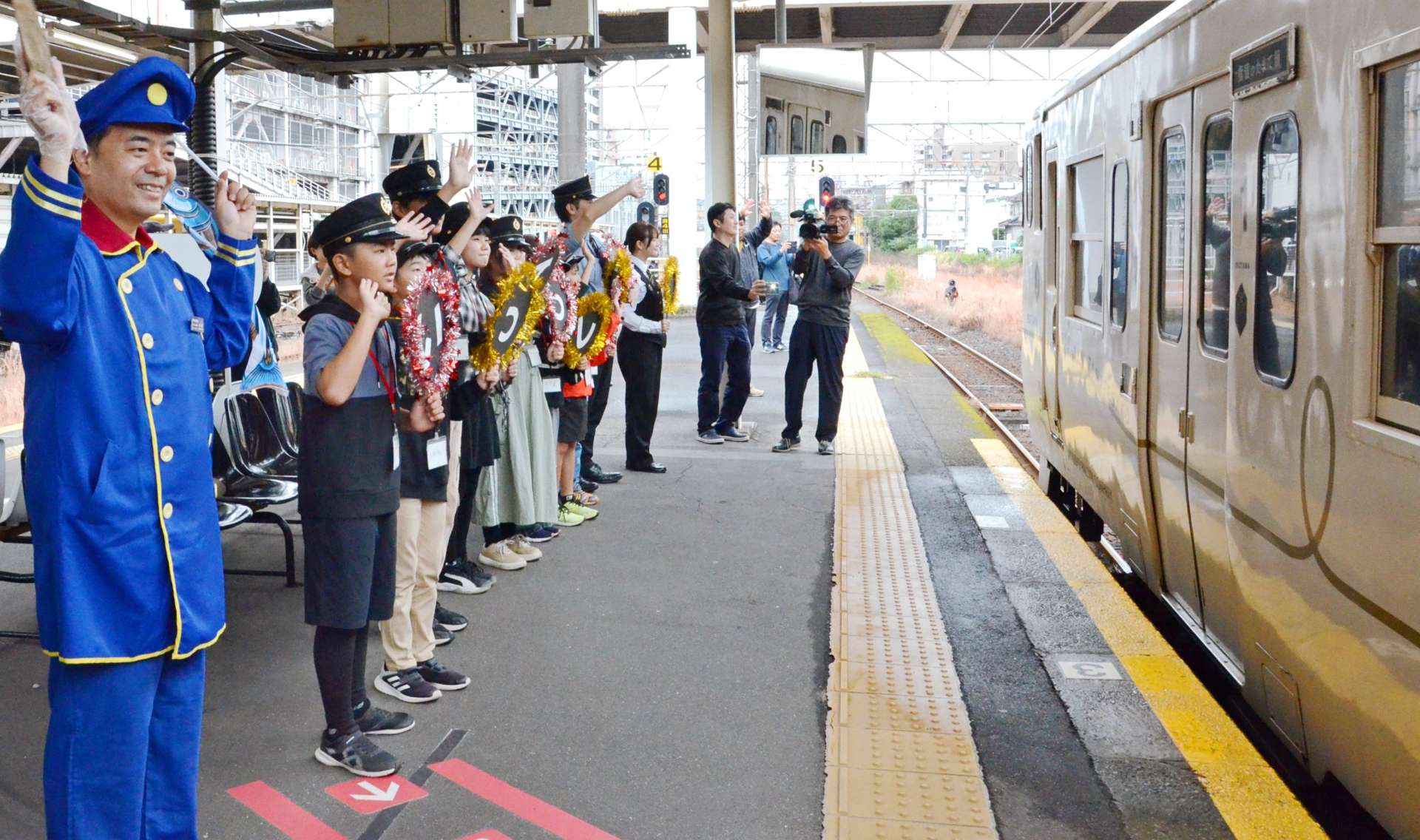 指宿枕崎線の観光特急「指宿のたまて箱」を見送る小学生ら＝１０日、鹿児島市のＪＲ鹿児島中央駅