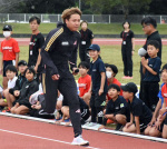 走り方の手本を見せる白石黄良々選手＝出水市のマルマエスタジアム出水