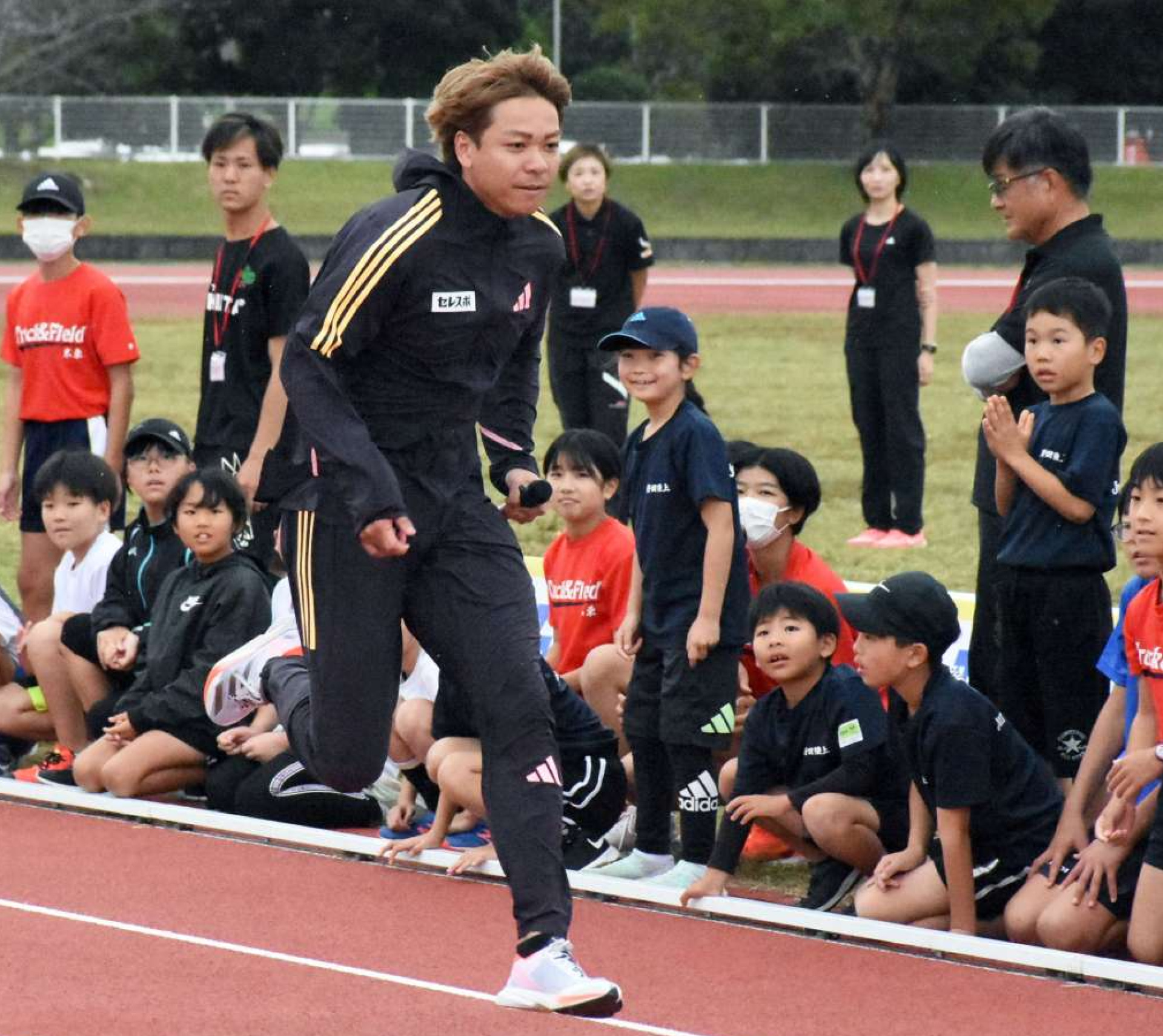 走り方の手本を見せる白石黄良々選手＝出水市のマルマエスタジアム出水