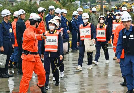 消防職員に誘導され赤水港に向かう住民役の学生ら＝１６日午前１０時２２分、鹿児島市桜島赤水町