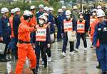 消防職員に誘導され赤水港に向かう住民役の学生ら＝１６日午前１０時２２分、鹿児島市桜島赤水町