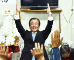 支援者と喜びを分かち合う橋本欣也氏（中央）＝１７日午後１０時２０分ごろ、伊佐市大口里