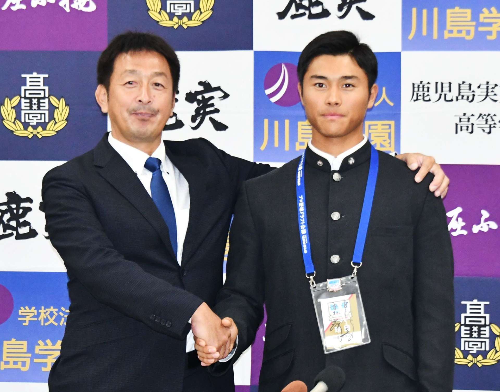 中日のスカウト担当者と握手を交わす鹿児島実高の井上剣也投手（右）＝同校