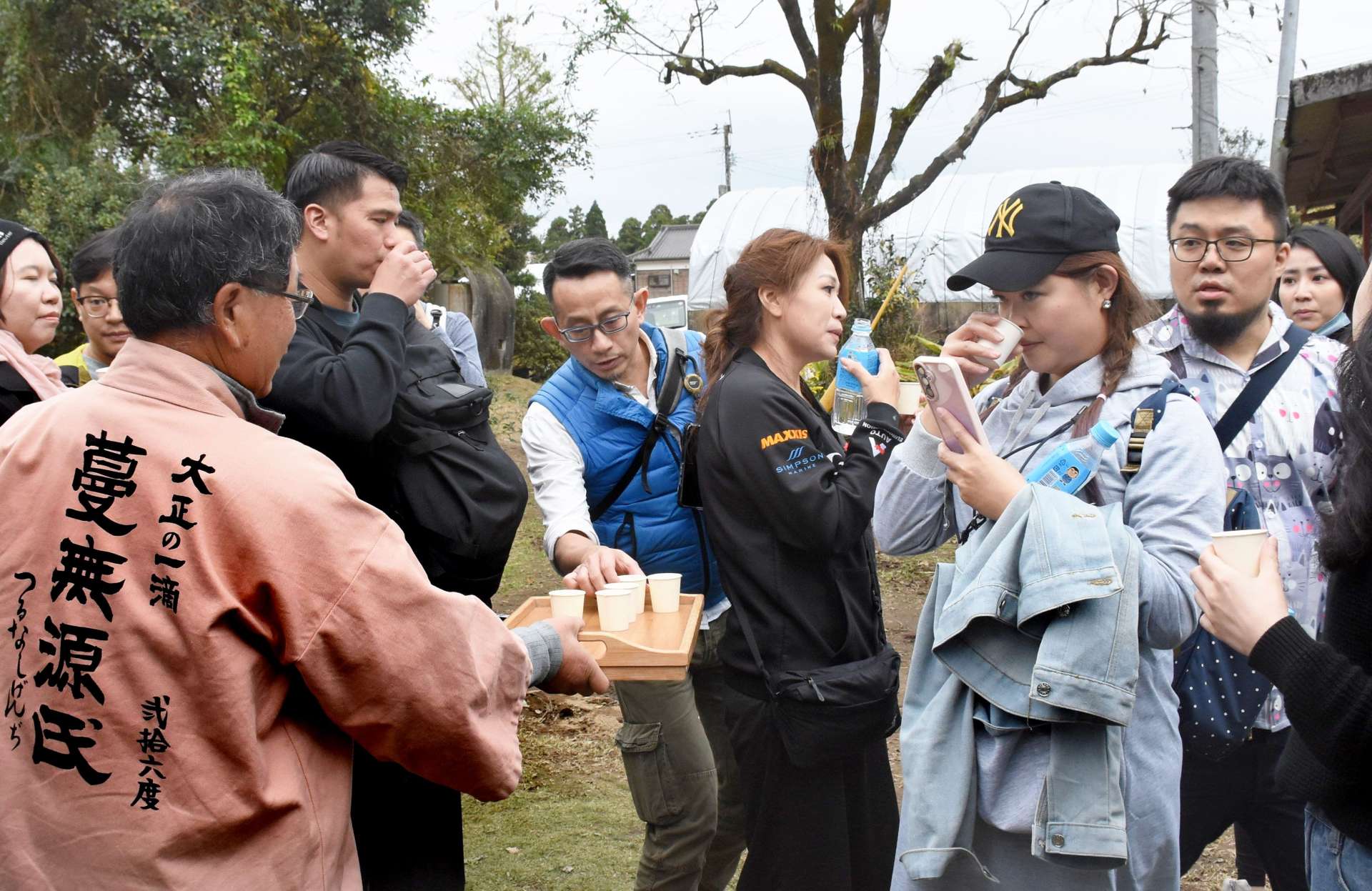 焼酎を試飲する台湾からのツアー客＝１９日、霧島市福山町佳例川の谷山農園