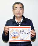 ライドシェア車両に貼るステッカーを持つ下小薗充社長＝２０日、伊佐市大口里の下小薗タクシー