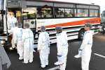 発生農場へ向かうバスに乗り込む県職員ら＝２０日午前６時４１分、出水市高尾野町大久保