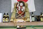 供え物と一緒に鎮座する田の神＝１９日午後、さつま町求名の下狩宿公民館
