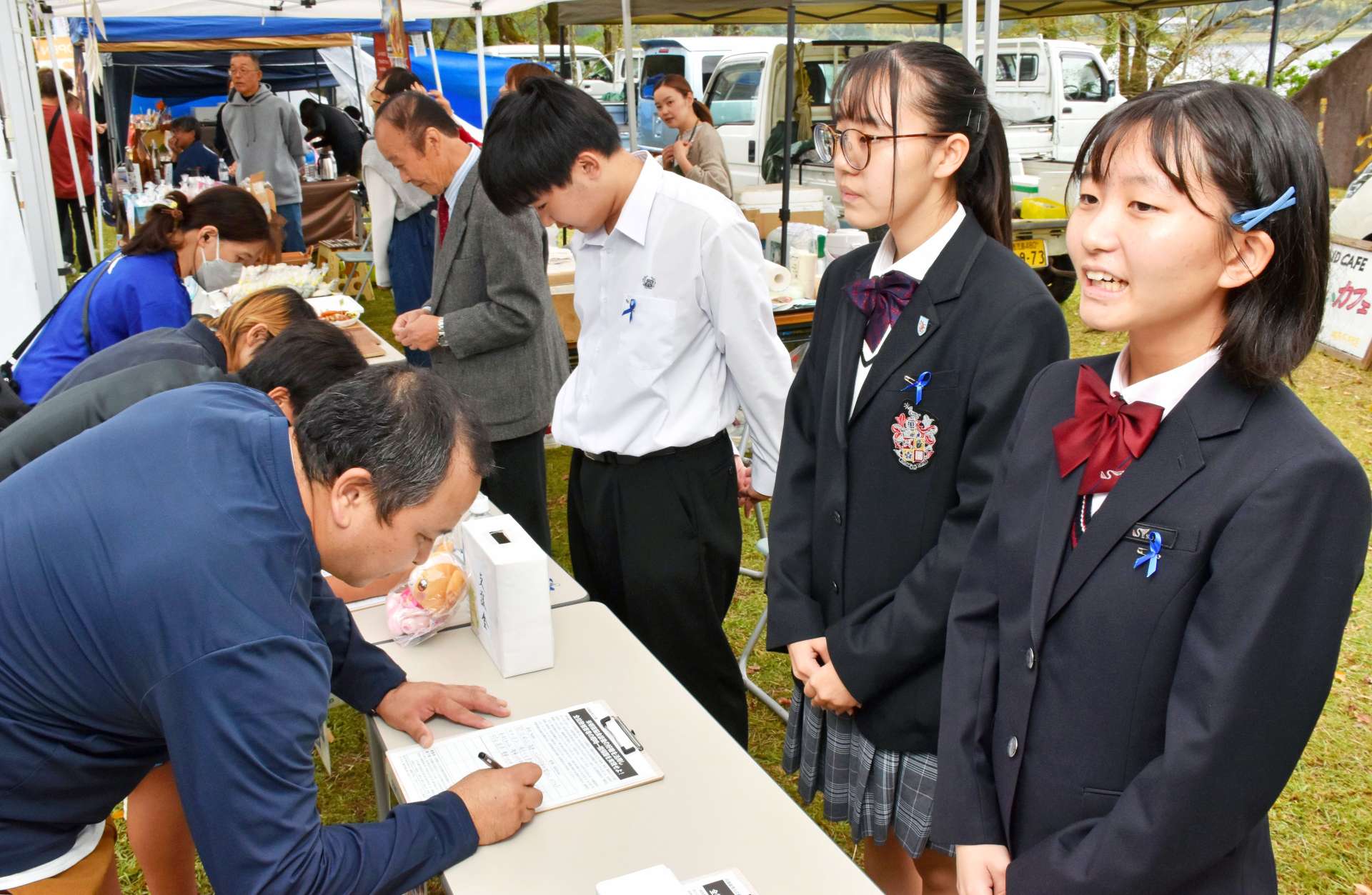 署名の協力を呼びかける羽島奈穂さん（右）たち＝薩摩川内市祁答院
