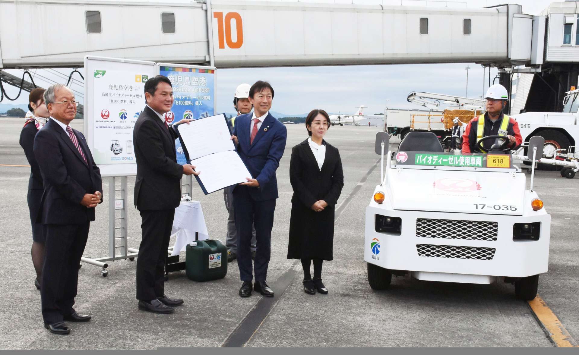 協定書を取り交わす中重真一霧島市長と、日本航空の中山洋彦鹿児島支店長＝２１日、鹿児島空港