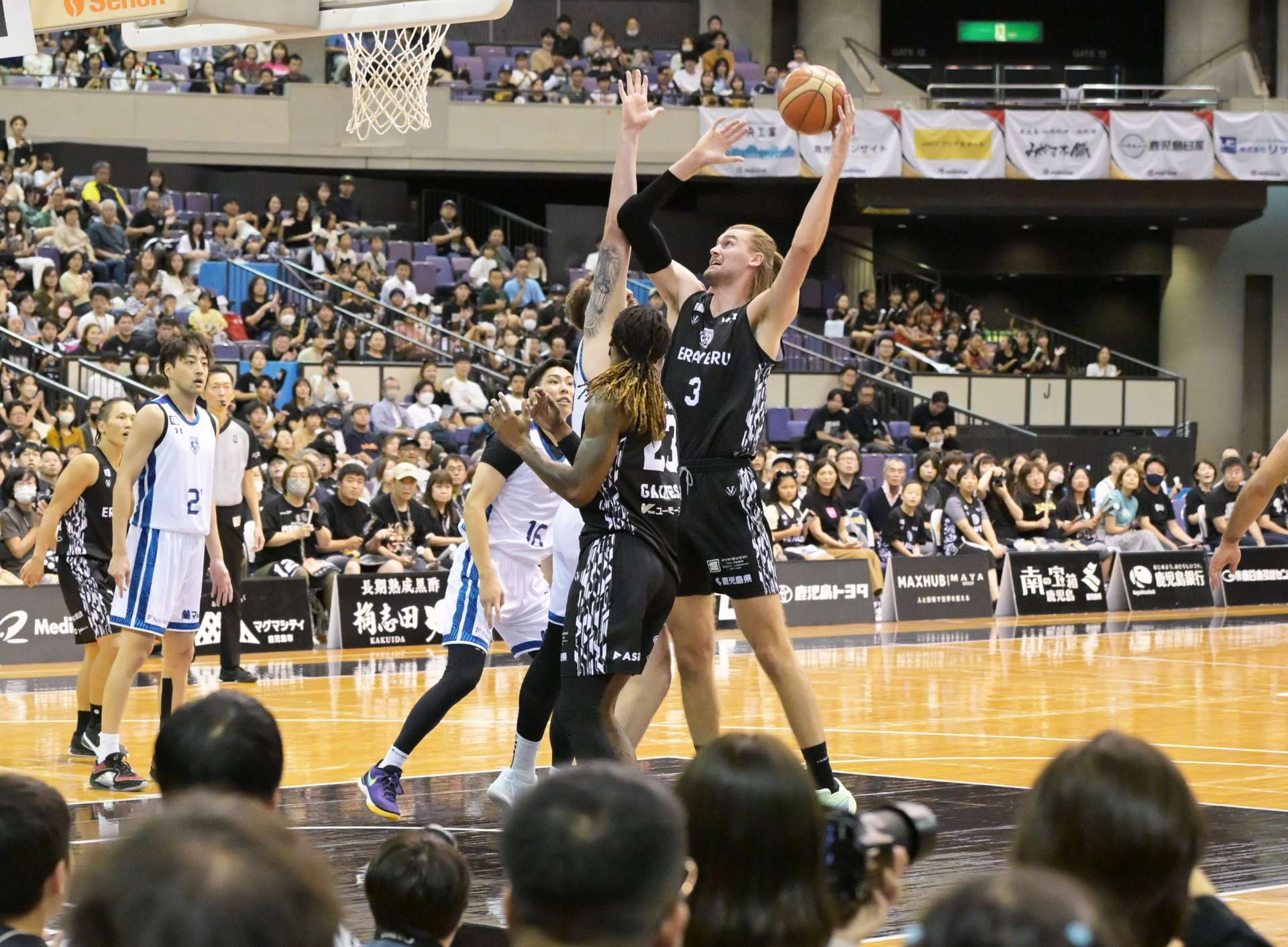 １０月１２日の福井戦、ゴール下で競り合うレブナイズのハームス（３）＝西原商会アリーナ