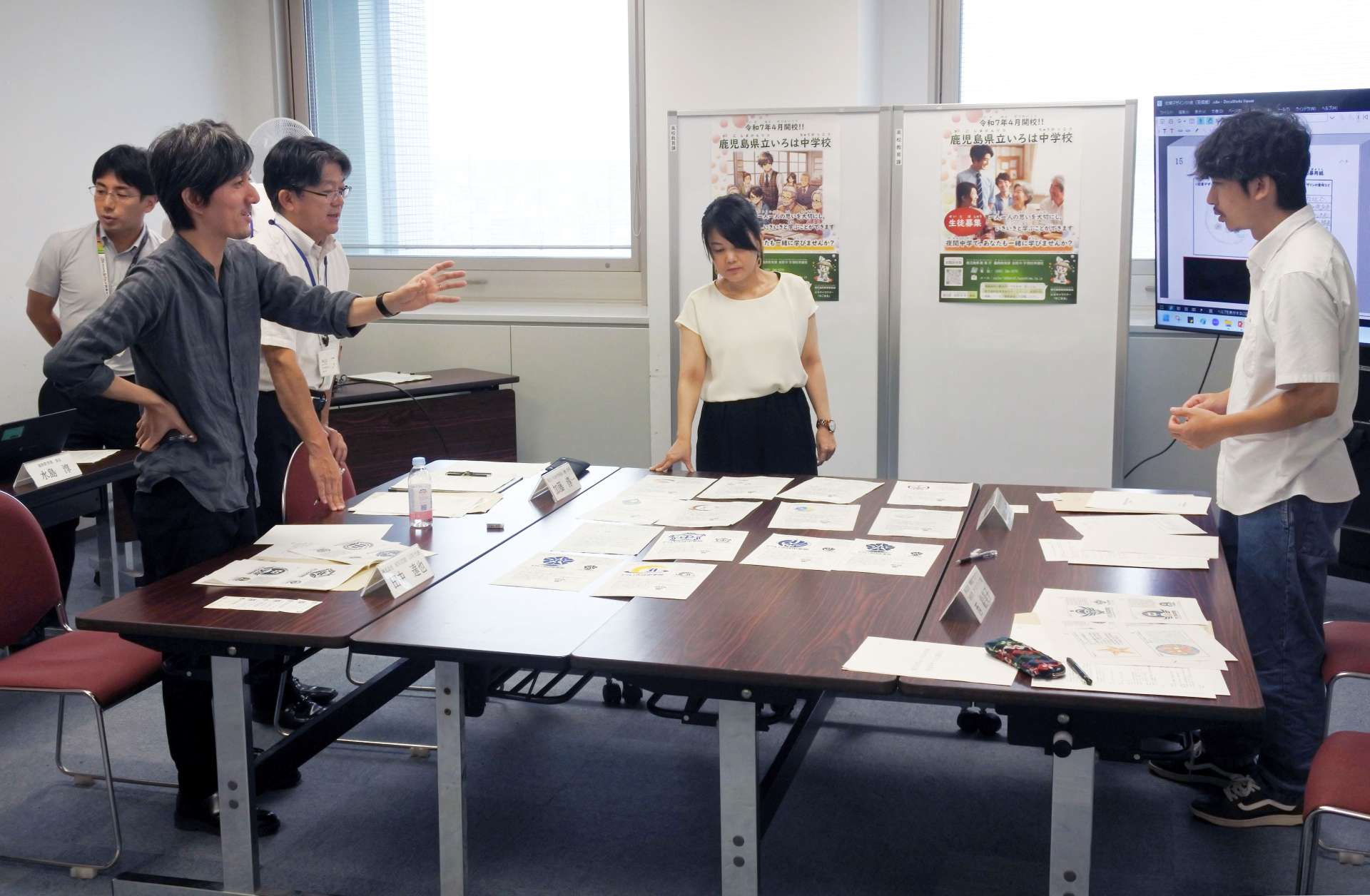 校章選定委員会で、いろは中の校章を選ぶ田中達也さん（手前左）