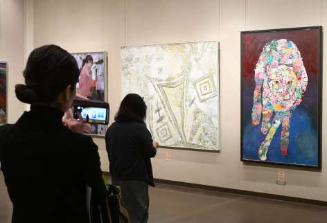 作品を写真撮影する来場者＝２３日、鹿児島市の黎明館