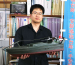 〈関連〉寄贈した震洋の１０分の１模型を持つ海田悟史さん＝瀬戸内町埋蔵文化財センター（海田さん提供）