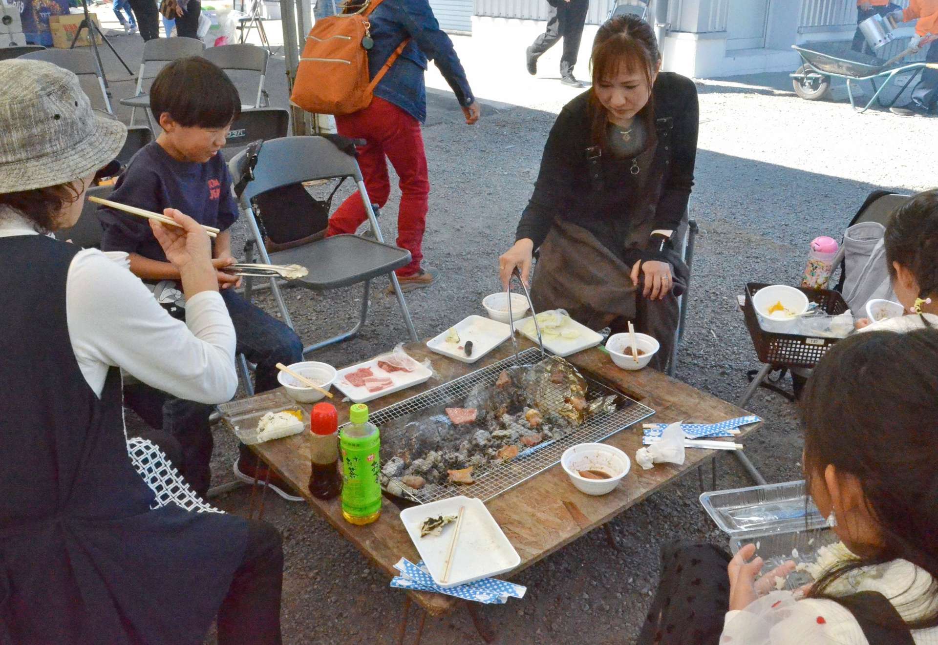 県産黒毛和牛などのバーベキューを楽しむ家族＝２３日、日置市伊集院