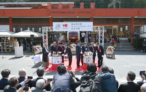 新駅舎オープニングセレモニーで鏡開きを行う関係者ら＝３月２２日、霧島市の霧島神宮駅