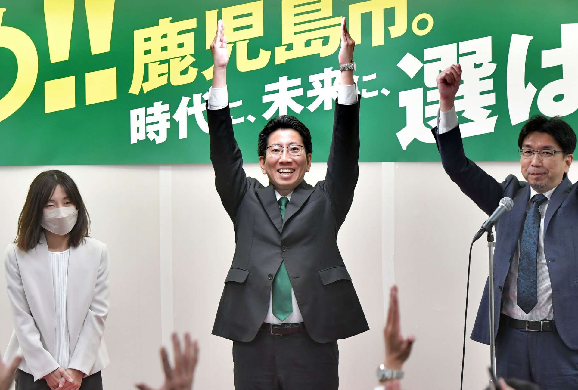 当選を確実にし、万歳して喜ぶ下鶴隆央さん＝２４日午後８時９分、鹿児島市東千石町